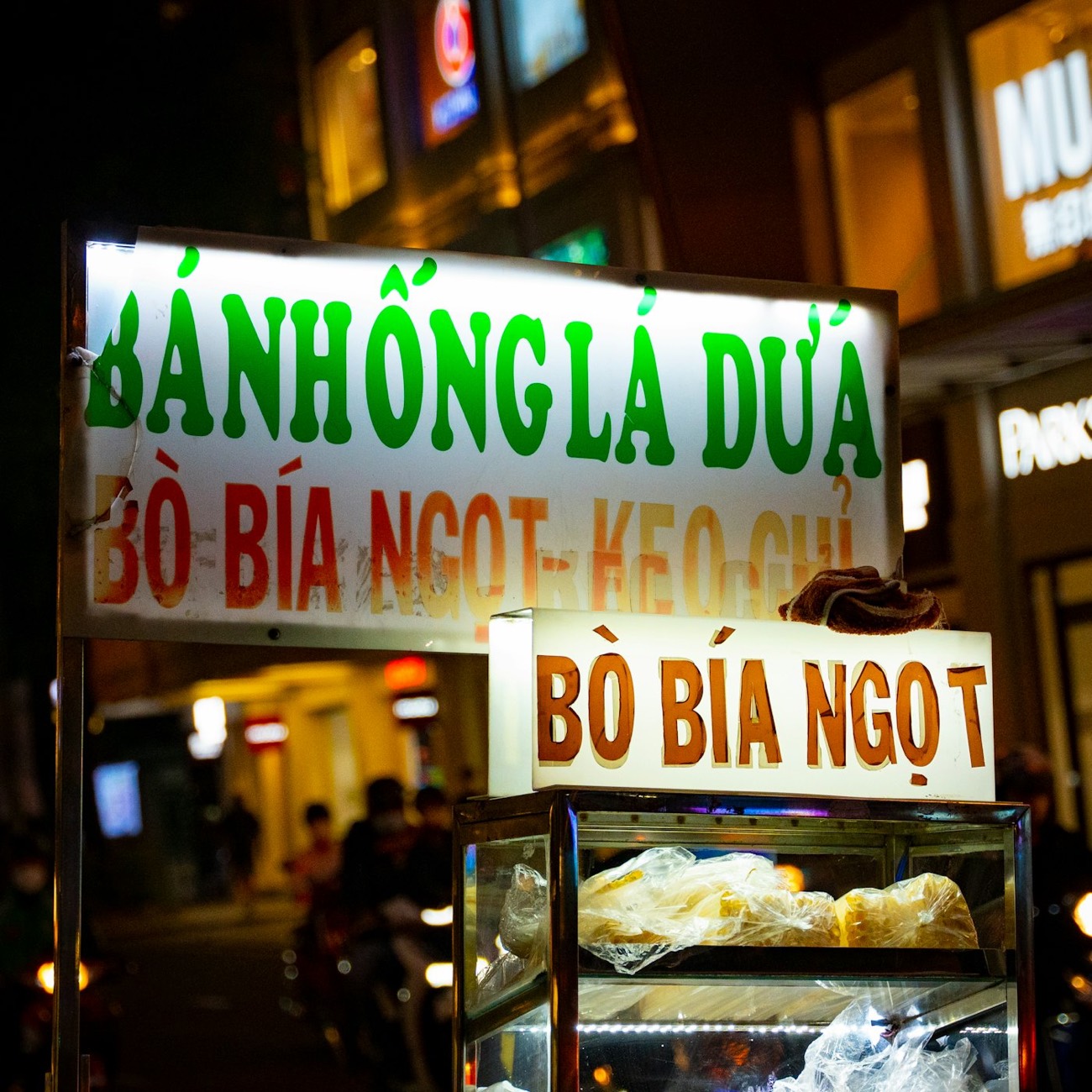 A Saigon street-food cart lit up at night