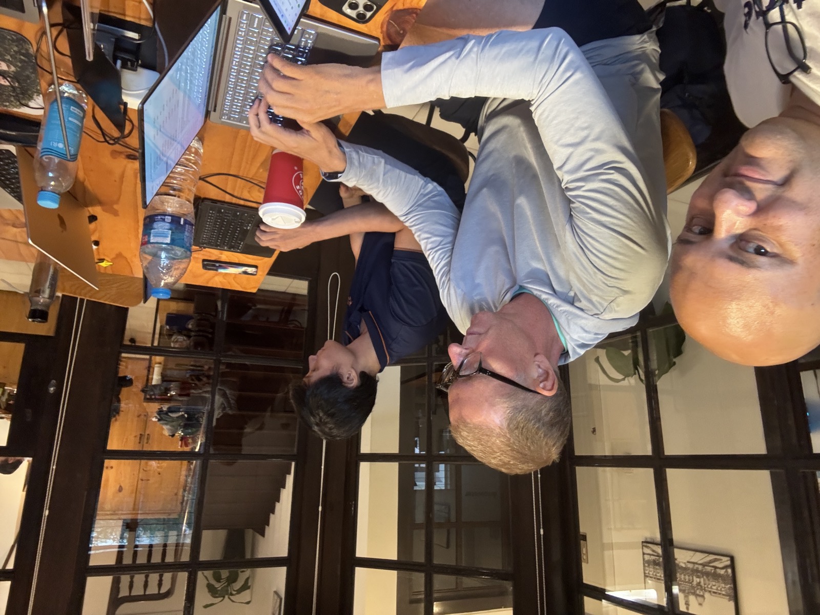 Guests and engineers working side by side at a wooden table